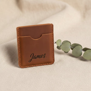 Brown leather card holder engraved with the name James in script font