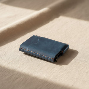 Blue personalized leather card holder and money clip wallet on linen