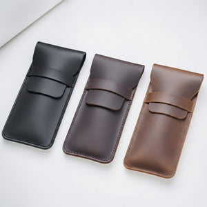 Three leather pen cases in black, brown and coffee on a white background