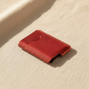 Red personalized leather card holder and money clip wallet on linen