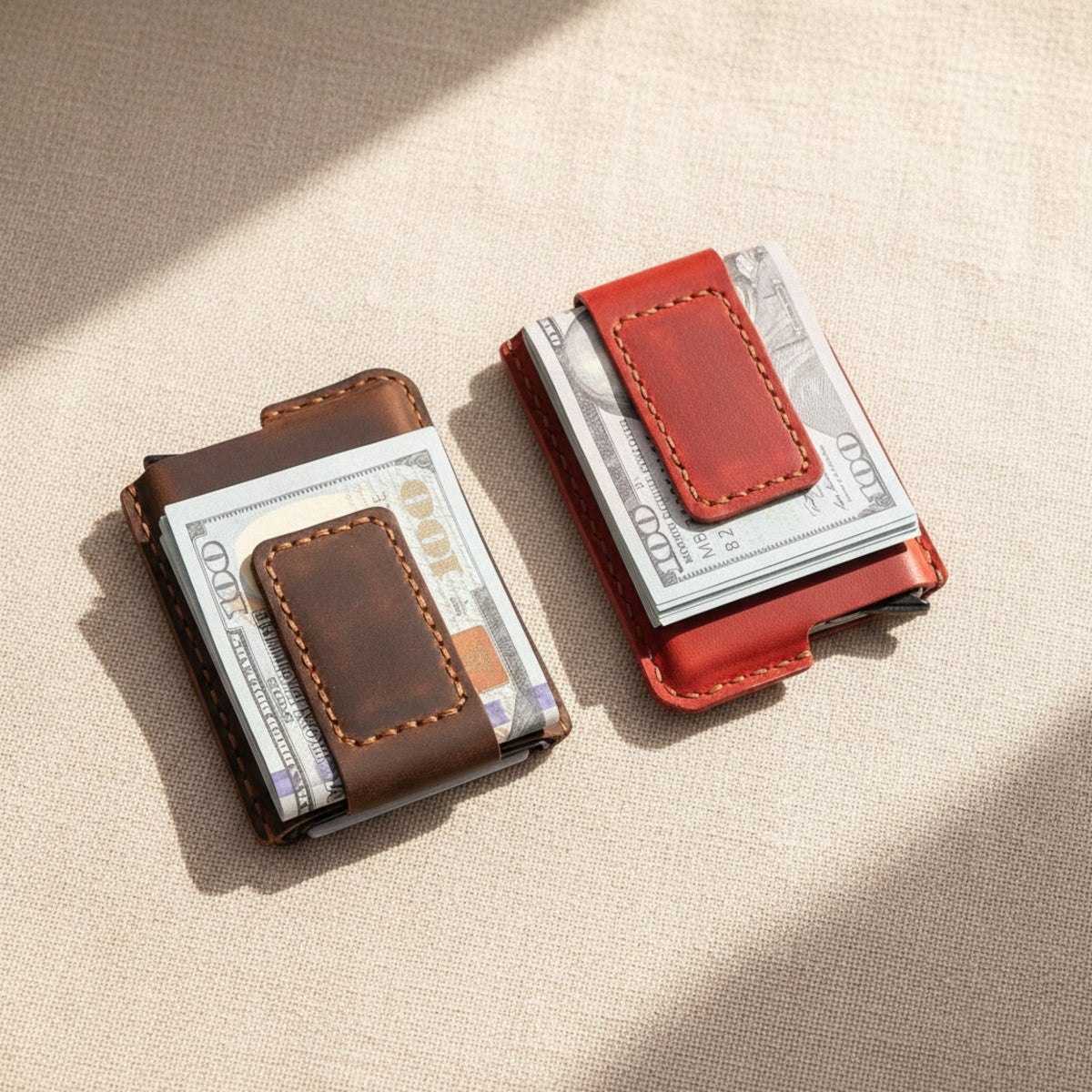 Brown and red personalized leather money clip wallets holding cash on linen