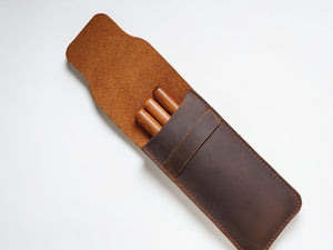 Brown leather pencil case open with wooden pencils inside