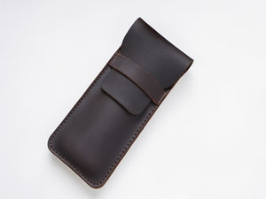 Coffee brown leather pen case with a magnetic snap strap on white