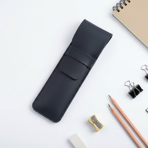Black personalized leather pencil case with stationery on a white background