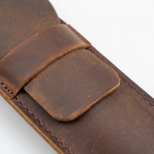 Close-up of the brown crazy horse leather flap and snap strap