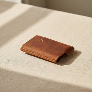 Brown personalized leather card holder lying flat in natural light