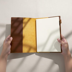 Open brown leather journal cover with blank refillable pages