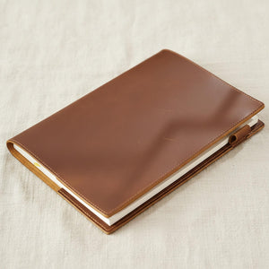 Closed brown leather journal cover with contrast saddle stitching