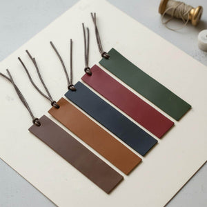 Custom engraved leather bookmark with waxed cord tassel on open book